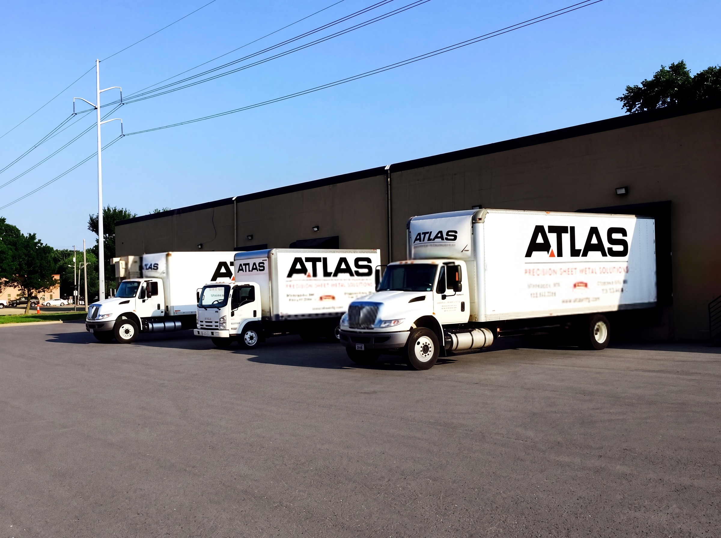 Atlas Manufacturing delivery trucks lined up outside the plant
