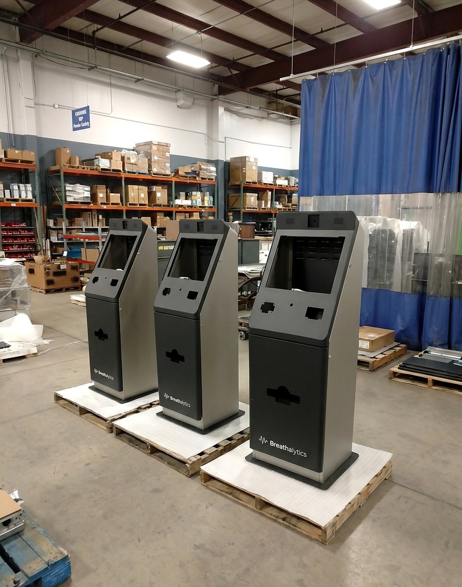 Three finished self-service kiosks on pallets on the Atlas floor, ready to ship