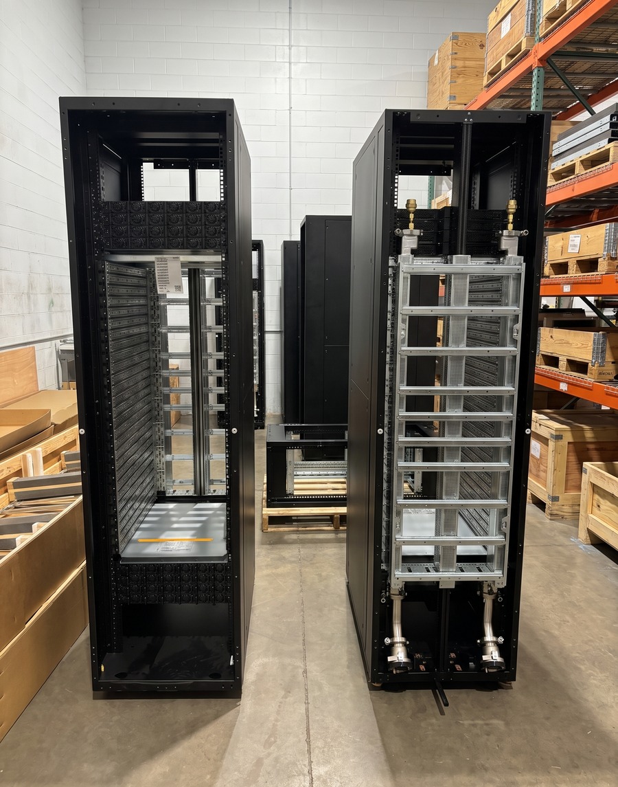 A production run of black server rack enclosures on the Atlas floor, one showing the front and one the back