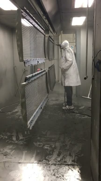 Operator spraying a panel on the in-house powder coat line